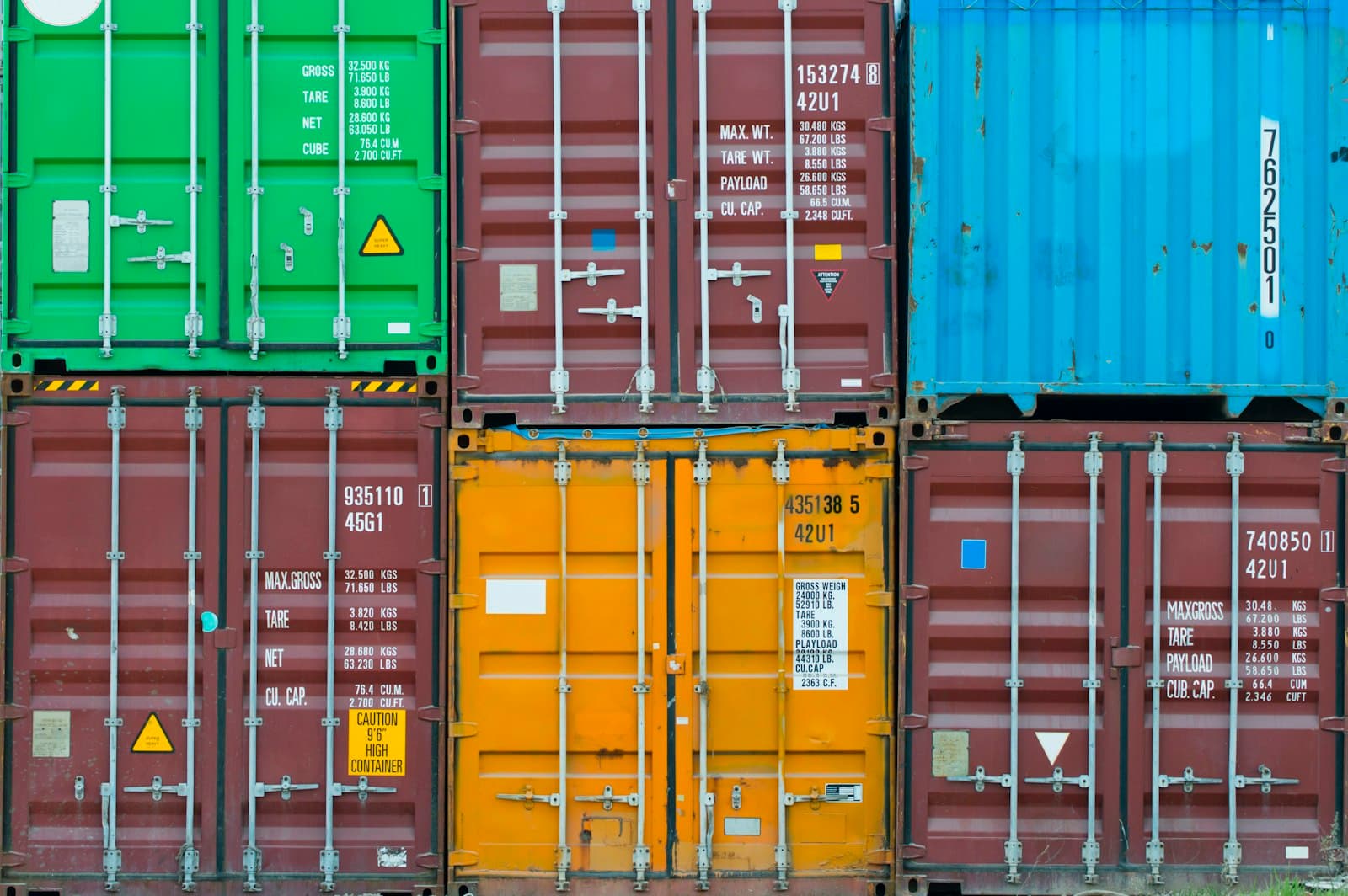 Kolorowe kontenery transportowe ułożone jeden na drugim