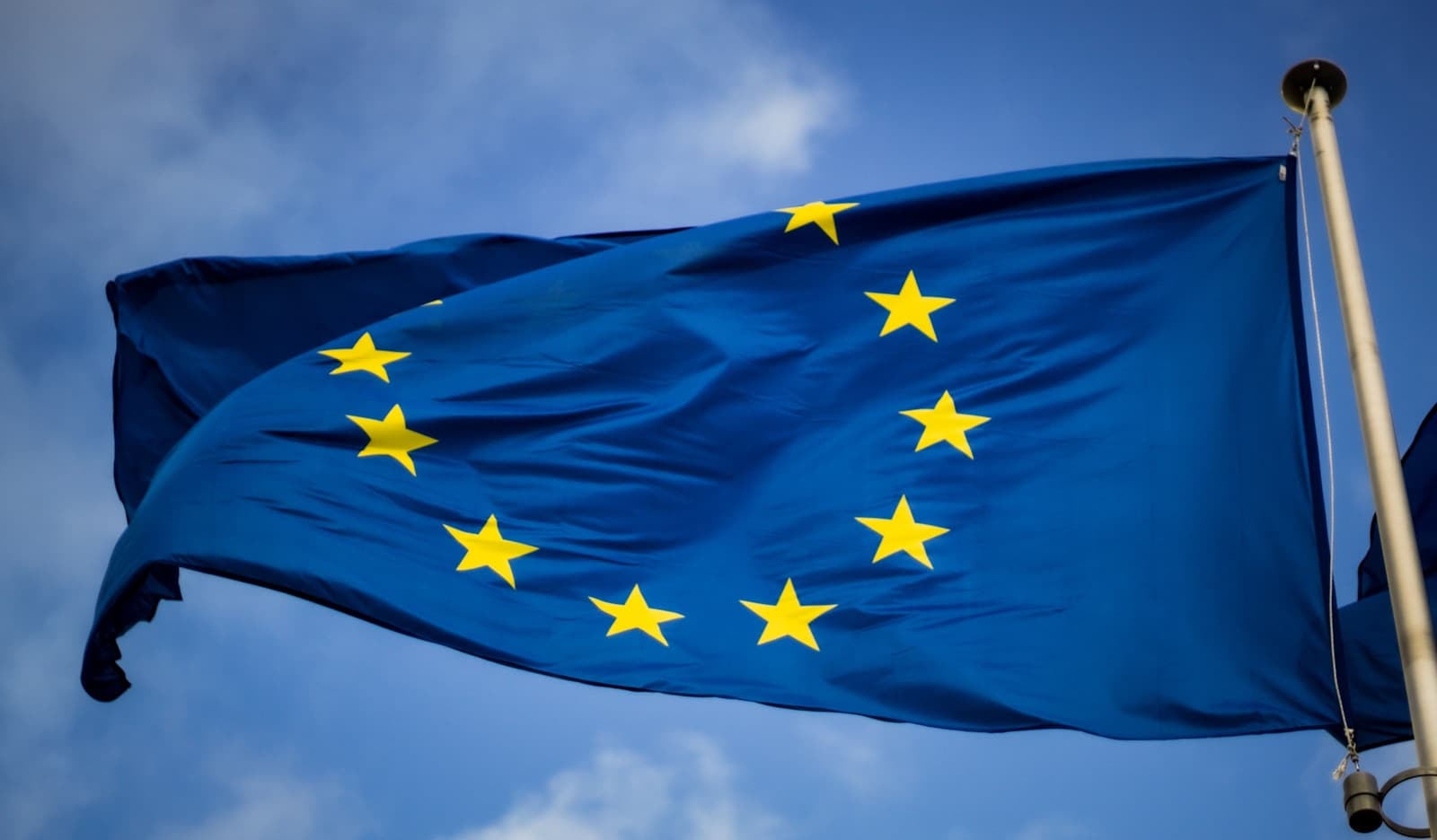 European Union flag in front of the European Parliament building in Brussels, photo by Christian Lue / Unsplash